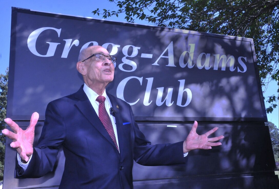 Photo of a man standing in front of a Gregg-Adams Club sign.