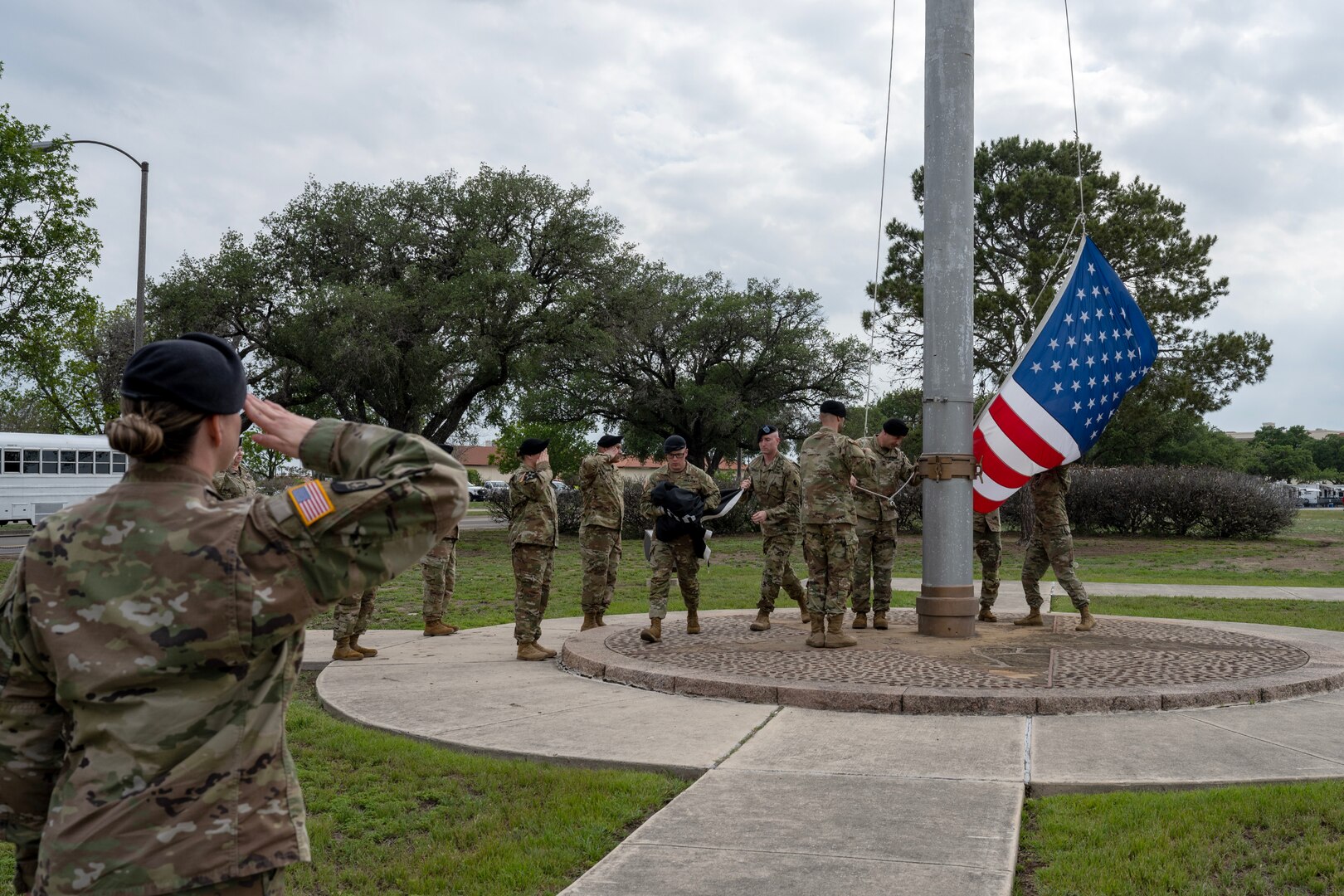 Military members taking down flag during retreat ceremony