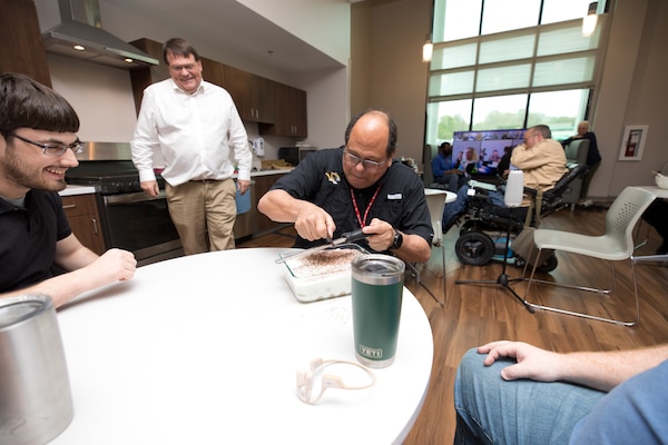 Dr. David Horner watches on while Dr. Guillermo Riveros puts chocolate on Tiramisu