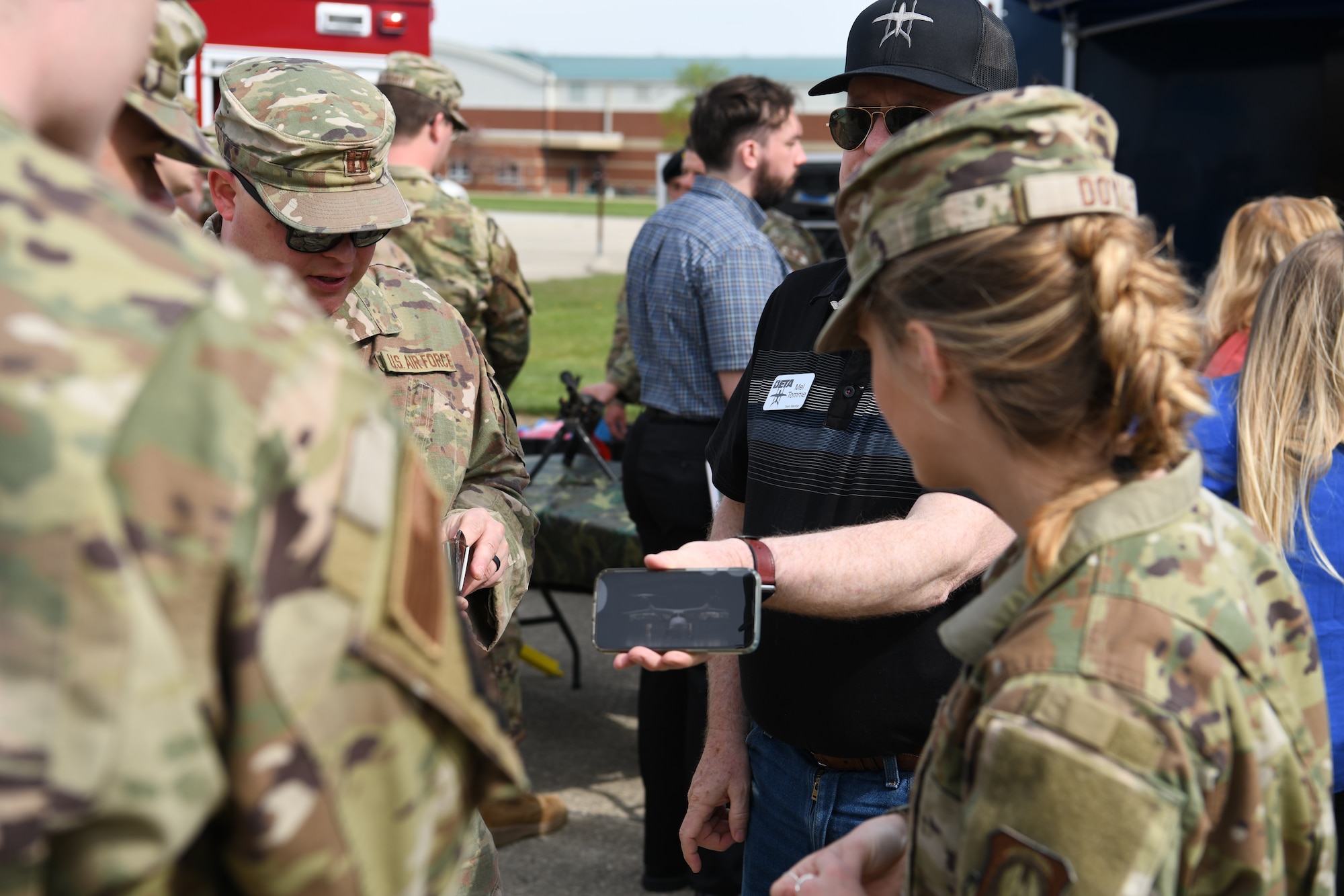 A community member shows a photo to ROTC members during the wing's Community Day, April 20, 2023 in Springfield, Ohio. The event consisted of a briefing on the wing's capabilities and a base tour. (U.S. Air National Guard photo by Senior Airman Jill Maynus)