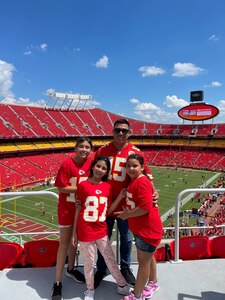 Tech. Sgt Ricardo Miranda-Navarro poses in Arrowhead Stadium ahead of a Kansas City Chiefs game with his daughters (from left to right) Anabella Miranda, Elena Miranda, and Katarina Miranda in Kansas City, Mo.
