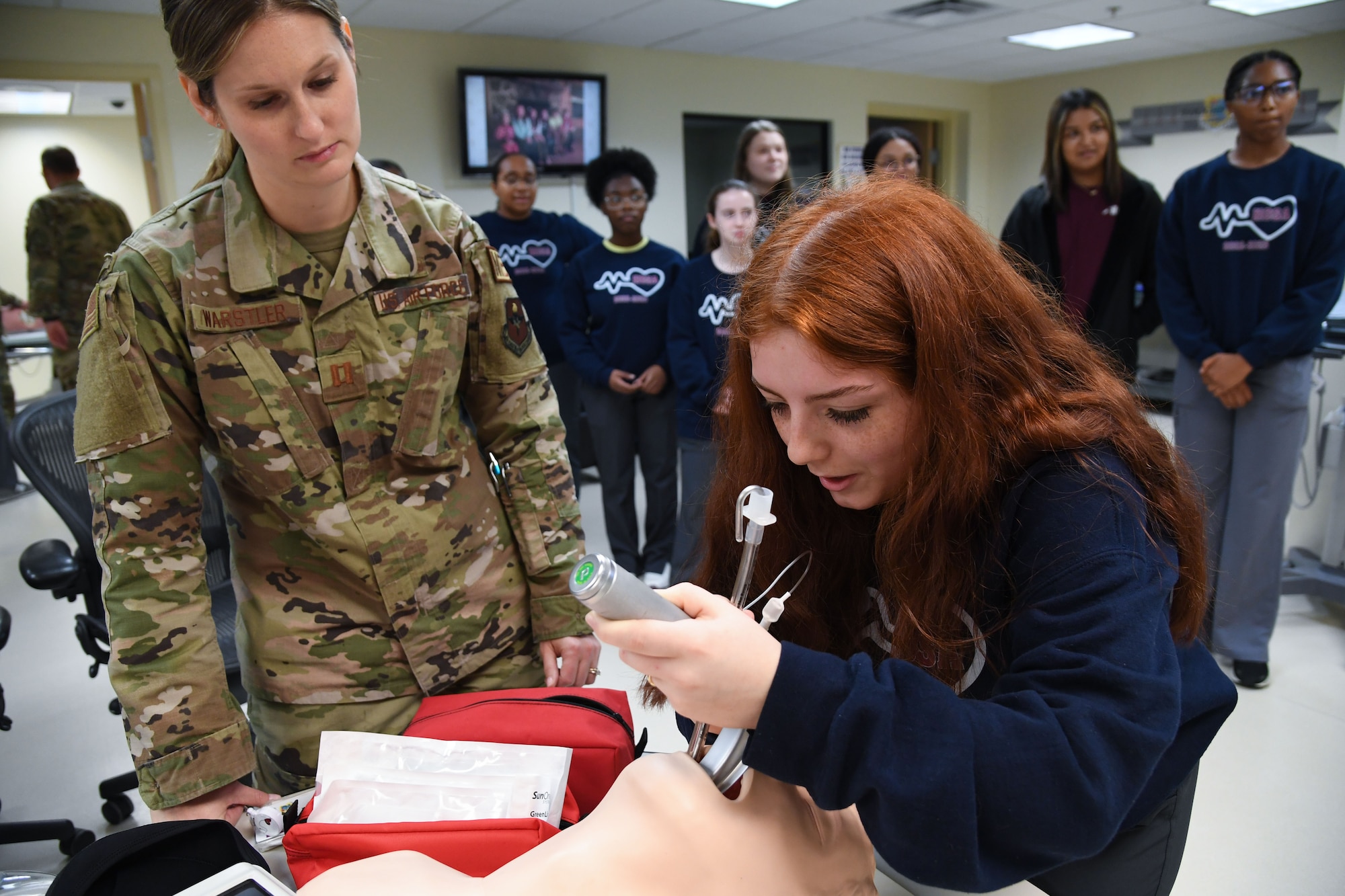U.S. Air Force Capt. Kimberly Warstler, 81st Healthcare Operations Squadron element chief, assists Arely Ochoa, Pascagoula High School student, with placing an airway tube in a training dummy inside the Keesler Medical Center at Keesler Air Force Base, Mississippi, April 21, 2023.