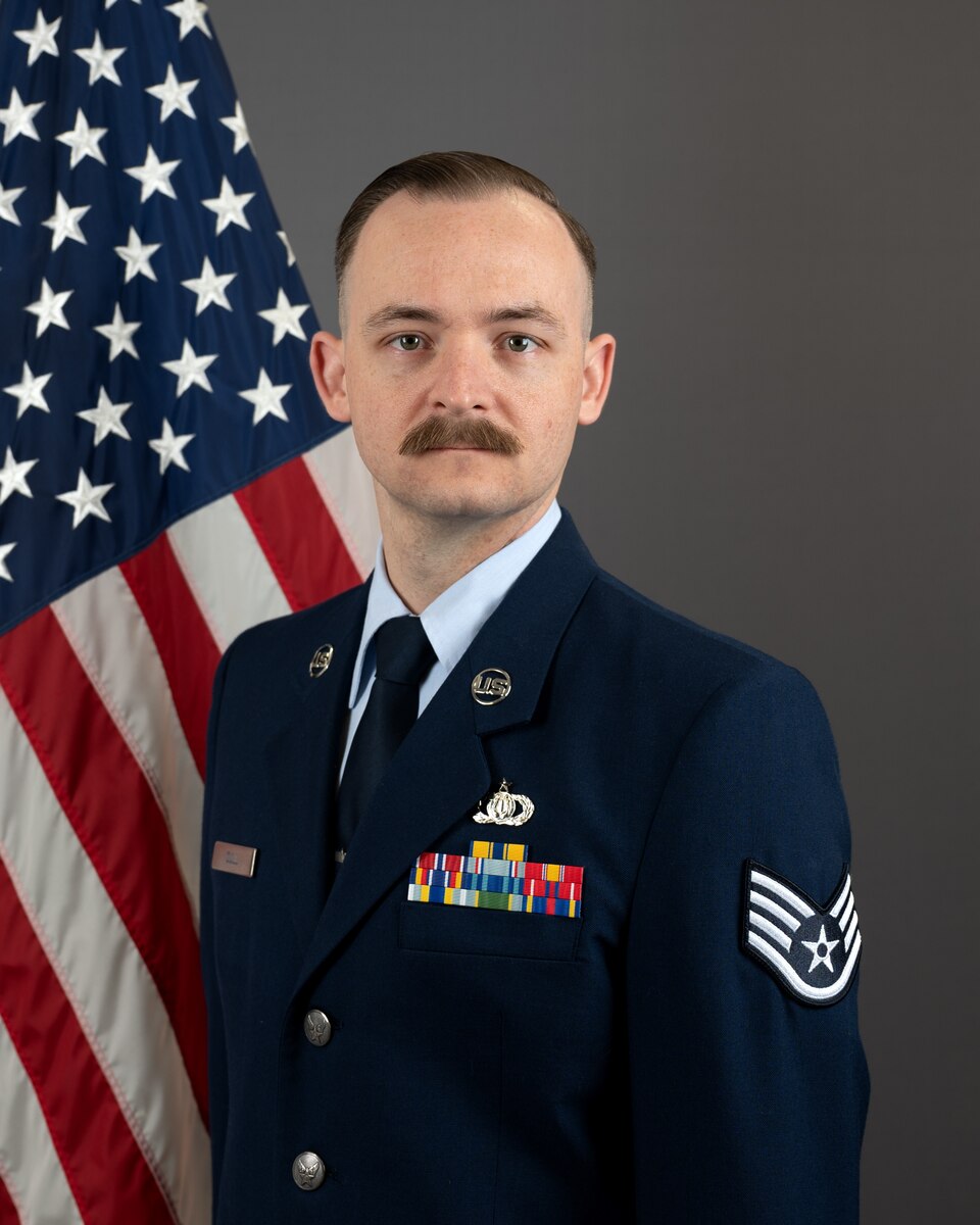 Official bio photo of Staff Sergeant Levi Cull in front of the American flag. He is wearing the blue service dress uniform.