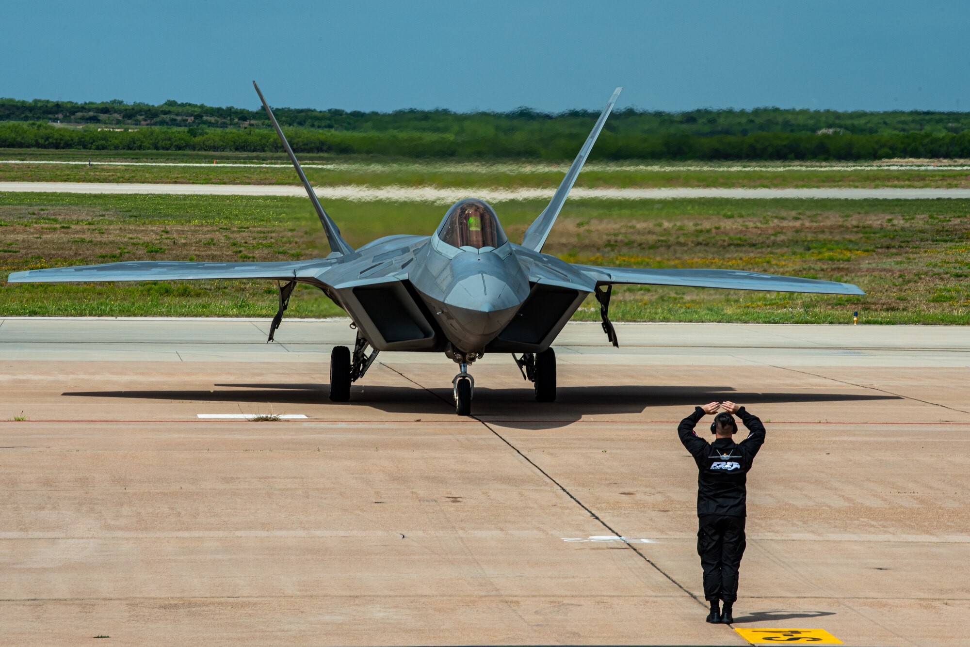 A F-22 Raptor sits on display during the 2023 Dyess Big Country Air Fest on Dyess Air Force Base, Texas, April 22, 2023. More than 30,000 event goers attended the one-day event highlighting the best of America’s only Lift and Strike base, Air Force heritage and Dyess community partners. The air show featured the F-22 Raptor demo team, U.S. Air Force Academy Wings of Blue, U.S. Army Golden Knights, WW II heritage flight and B-1B Lancer and C-130J Super Hercules fly overs. (U.S. Air Force photo by Airman 1st Class Alondra Cristobal Hernandez)
