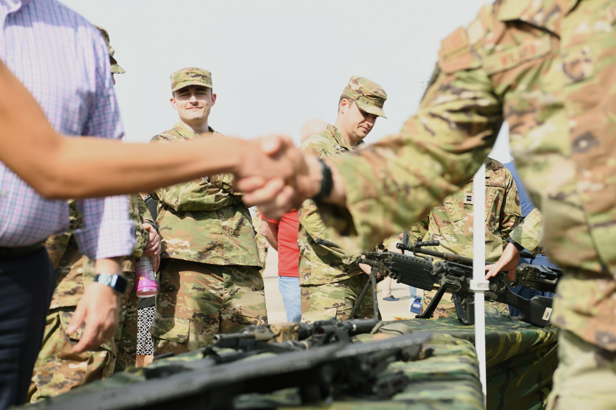 A member of ROTC watches as a Security Forces Airmen assigned to the Ohio Air National Guard’s 178th Wing shakes hands with a member of the community during the wing's Community Day, April 20, 2023 in Springfield, Ohio. The attendees toured hands-on displays of tools and technology used to fulfill the wings mission. (U.S. Air National Guard photo by Senior Airman Jill Maynus)