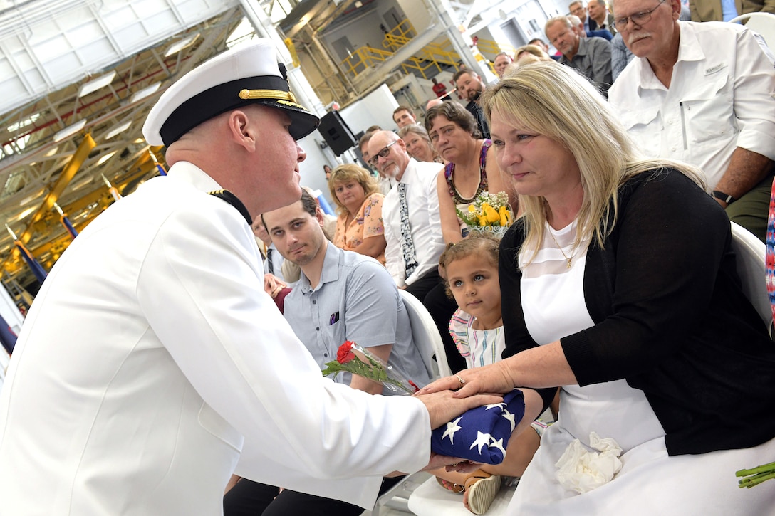 230421-N-DG679-006
JACKSONVILLE, Fla. (Apr. 21, 2023) Capt. Grady Duffey presents the national ensign to his wife, Kandi Duffey, during the Fleet Readiness Center Southeast (FRCSE) change of command ceremony. Capt. William Palmer became FRCSE’s 45th commanding officer after relieving Capt. Grady Duffey during a change of command and retirement ceremony April 21st onboard Naval Air Station Jacksonville. (U.S. Navy photo by Toiete Jackson/Released)