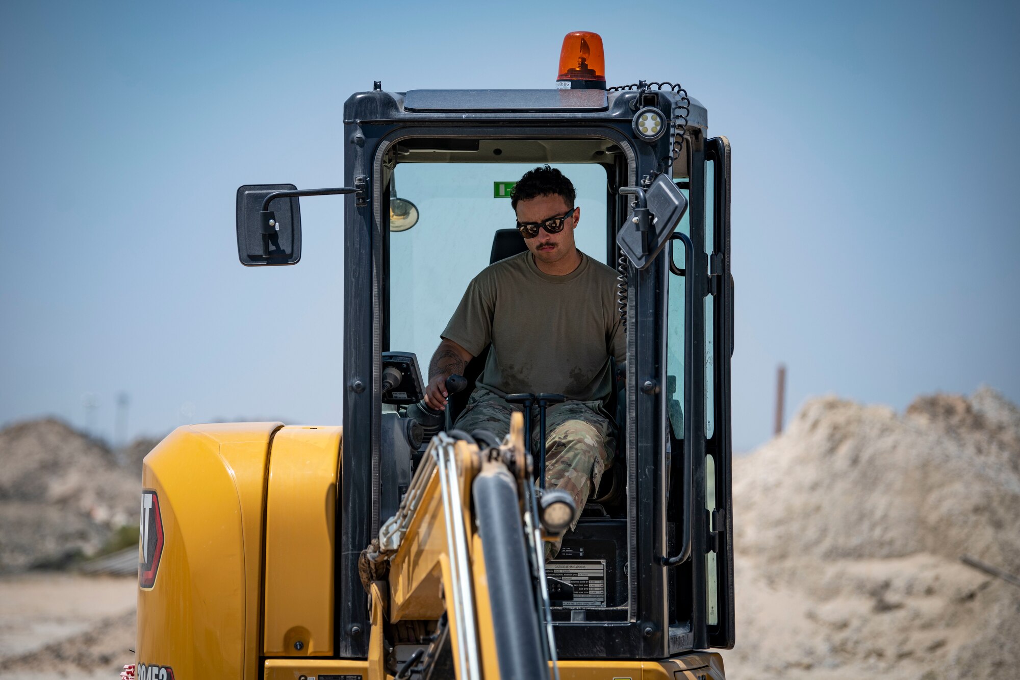 U.S. Air Force Airman 1st Class Ian Mitchell, a 386th Expeditionary Civil Engineer Squadron pavements and construction journeyman, digs a trench during the installation process for a new tower at Cargo City, Kuwait, April 19, 2023.