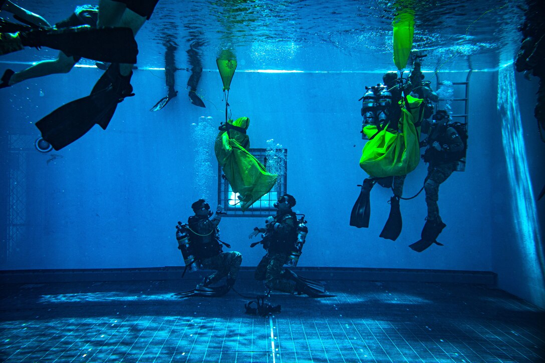 Airmen train underwater in a swimming pool.