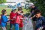DAHLGREN, Va. (April 20, 2023) -- Travis Wray, Naval Support Facility Dahlgren natural resources program manager, holds a trash bag for students from Dahlgren Middle School, as they clean up trash on Naval Support Facility Dahlgren.