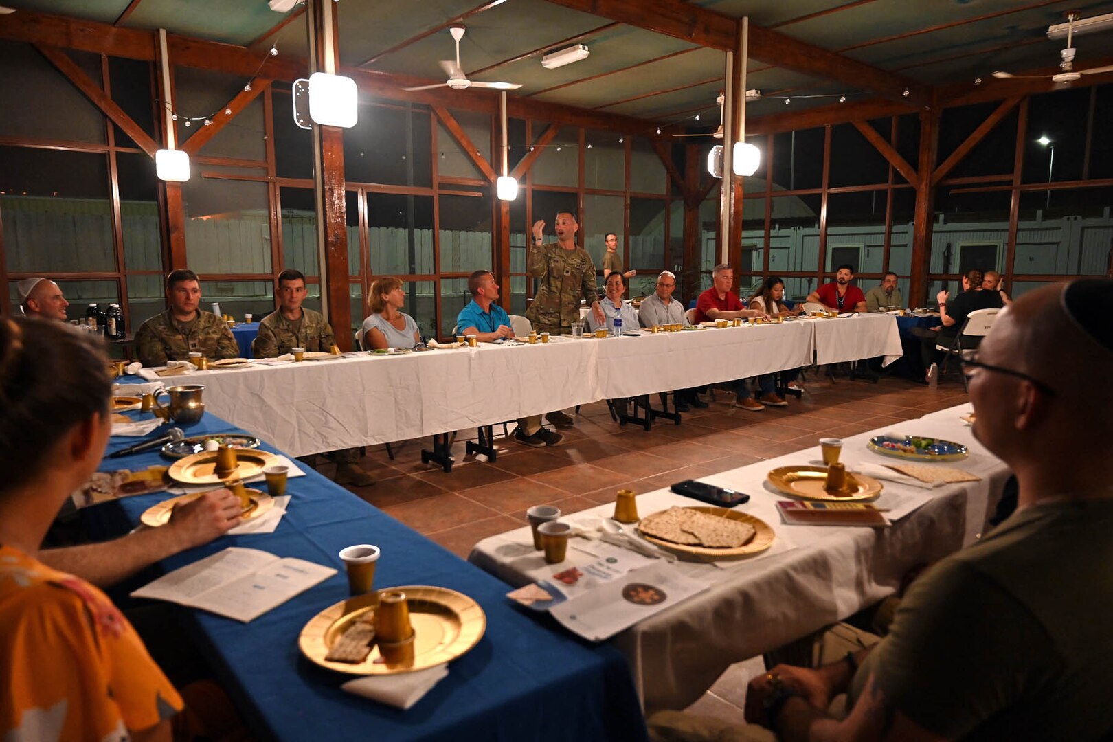 service members sit around table for Passover dinner