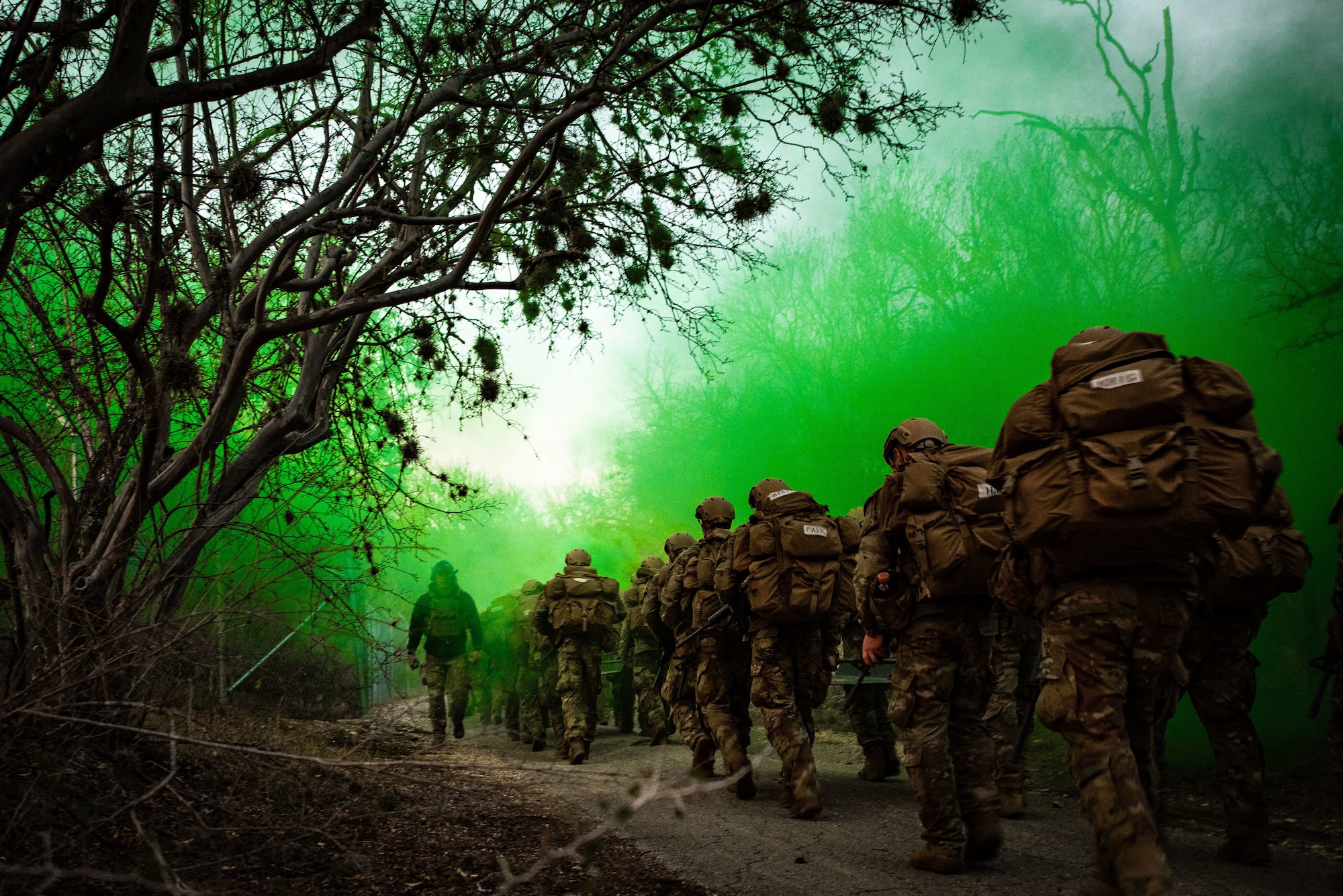 Instructor walks towards camera through green smoke while students march away