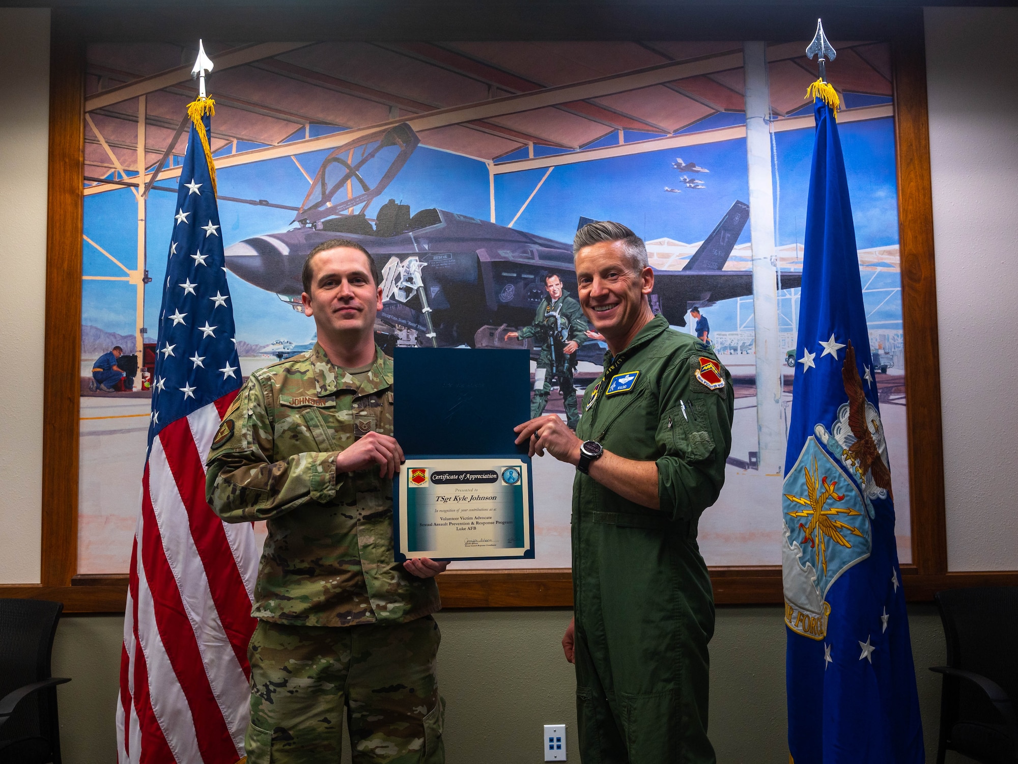 U.S. Air Force Col. Keegan McLeese, (right) 56th Fighter Wing vice commander, presents an award to Tech. Sgt. Kyle Johnson (left), 56th Fighter Wing volunteer victim advocate, April 21, 2023, at Luke Air Force Base, Arizona.