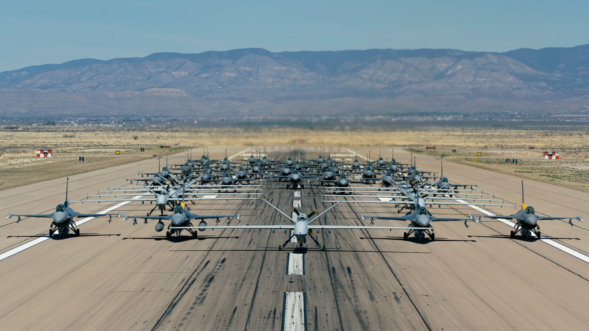 Forty-nine F-16 Vipers and MQ-9 Reapers assigned to the 49th Wing line up on the runway during an elephant walk at Holloman Air Force Base, New Mexico, April 21, 2023.