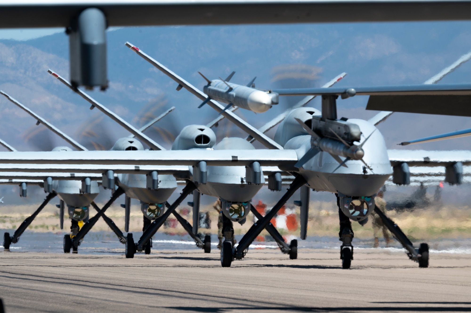 Forty nine MQ-9 Reapers and F-16 Vipers assigned to the 49th Wing line up on the runway during an elephant walk at Holloman Air Force Base, New Mexico, April 21, 2023.