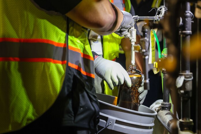 Fuel operators with Joint Task Force-Red Hill (JTF-RH) collect a fuel sample during dewatering at the Red Hill Bulk Fuel Storage Facility in Halawa, Hawaii, April 18, 2023.