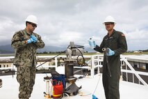 U.S. Navy Aviation Boatswain’s Mate 2nd Class Jake G. Hamilton, left, and Aviation Boatswain’s Mate 3rd Class Stuart M. Price with Fuels Services Division, Marine Corps Base Hawaii, collect a fuel sample during a personnel qualification standard demonstration for analysts with Expeditionary Energy Office (E2O), Headquarters Marine Corps, at MCBH, April 13, 2023. Analysts with E2O met with Marines and Sailors with Fuels Services Division to develop an advanced training package that will provide Marines exposure to commercial resourcing, industry practices, and quality assurance and surveillance methods at the regional level. (U.S. Marine Corps photo by Cpl. Brandon Aultman)