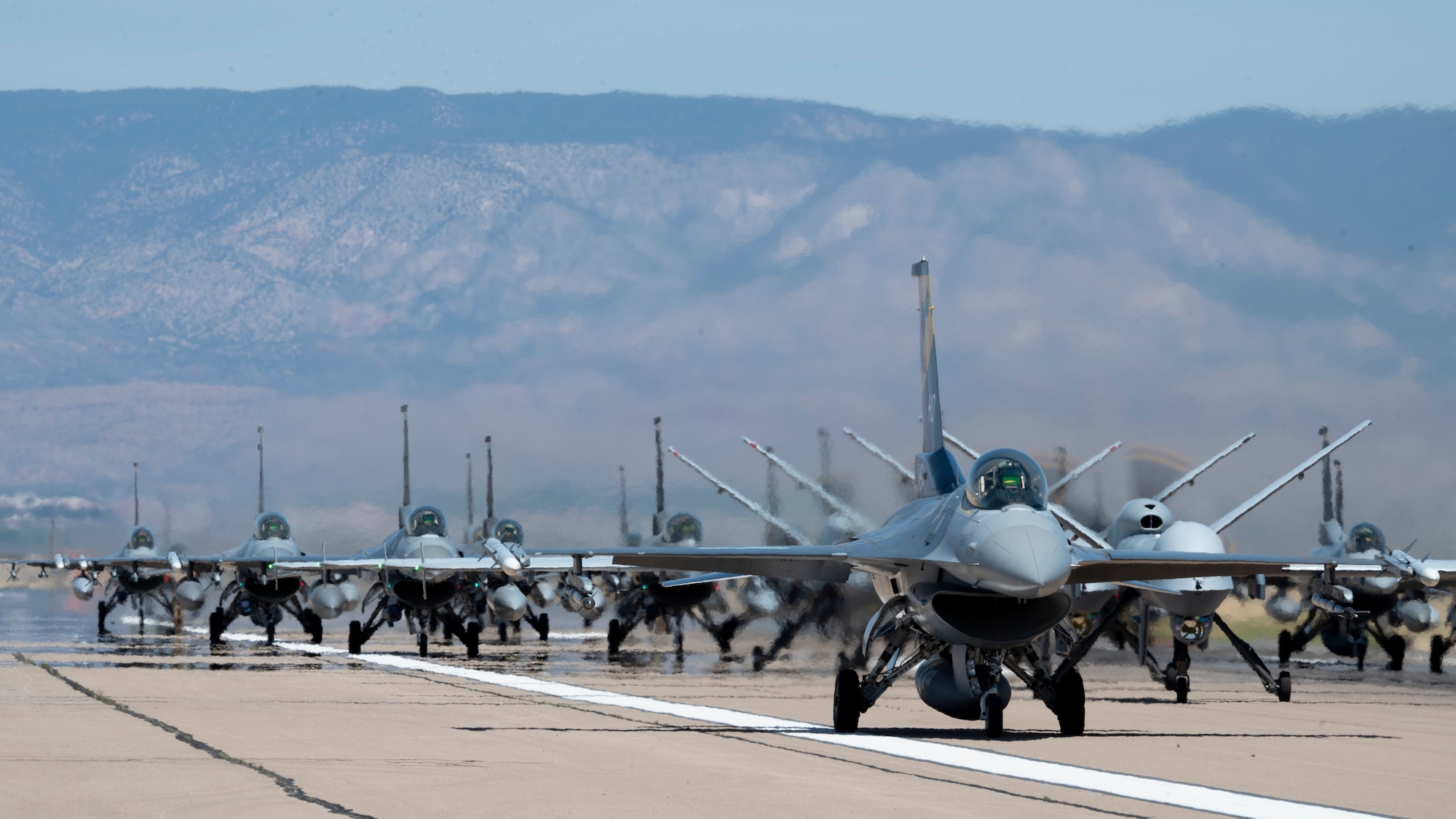Forty-nine F-16 Vipers and MQ-9 Reapers assigned to the 49th Wing line up on the runway during an elephant walk at Holloman Air Force Base, New Mexico, April 21, 2023.