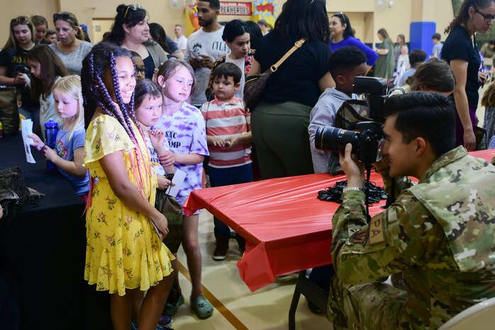 A group of children get their “passport” photo taken for the Day for Kids event at the Youth Center on Beale Air Force Base, California, April 21, 2023.