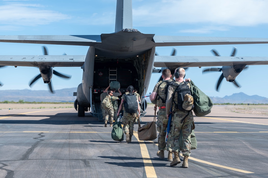 U.S. Air Force Airmen assigned to the 56th Fighter Wing enter the cargo hold of a C-130J Hercules assigned to the 317th Airlift Wing, Dyess Air Force Base, Texas, during exercise Wild Coyote, April 13, 2023, at Gila Bend Air Force Auxiliary Field, Arizona.