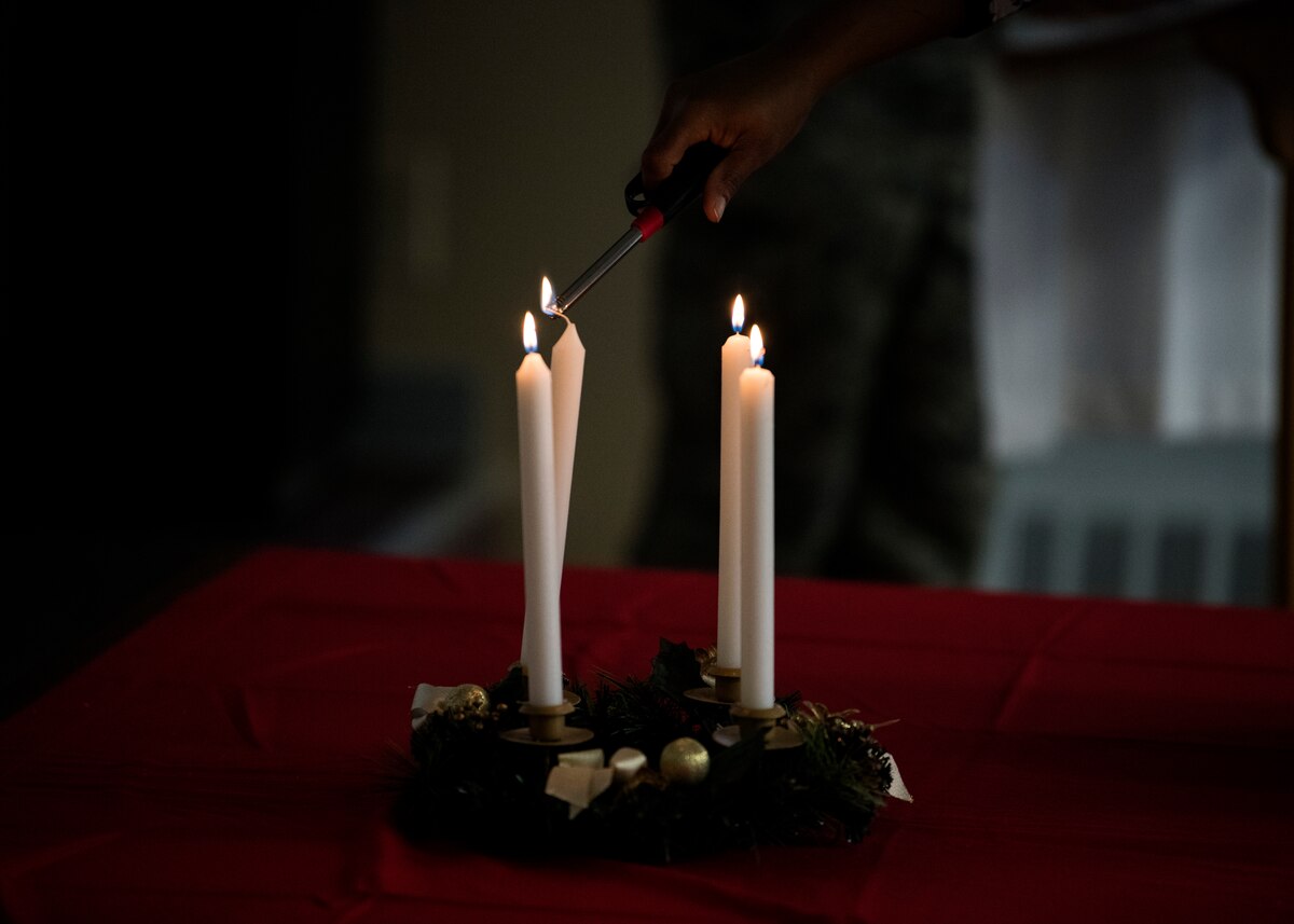 An Airman's family member lights a candle during a candle lighting ceremony as a way to reminisce and connect at Barnes Air National Guard, Mass., Dec. 2, 2018.