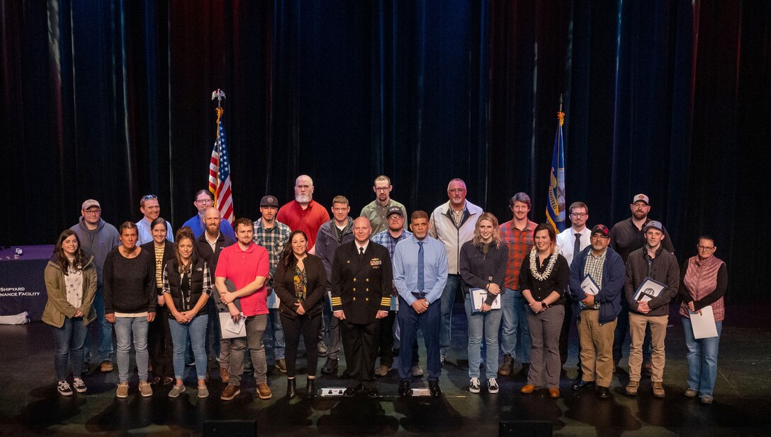 Puget Sound Naval Shipyard & Intermediate Maintenance Facility Employee of the Year nominees, their co-workers, friends and family gathered Tuesday at the Admiral Theater in downtown Bremerton, Washington, to honor the command’s top employees during the shipyard’s annual recognition ceremony. Capt. Jip Mosman, commander, PSNS & IMF, with the winners of various Employee of the Year categories. (U.S Navy Photo by Wendy Hallmark)
