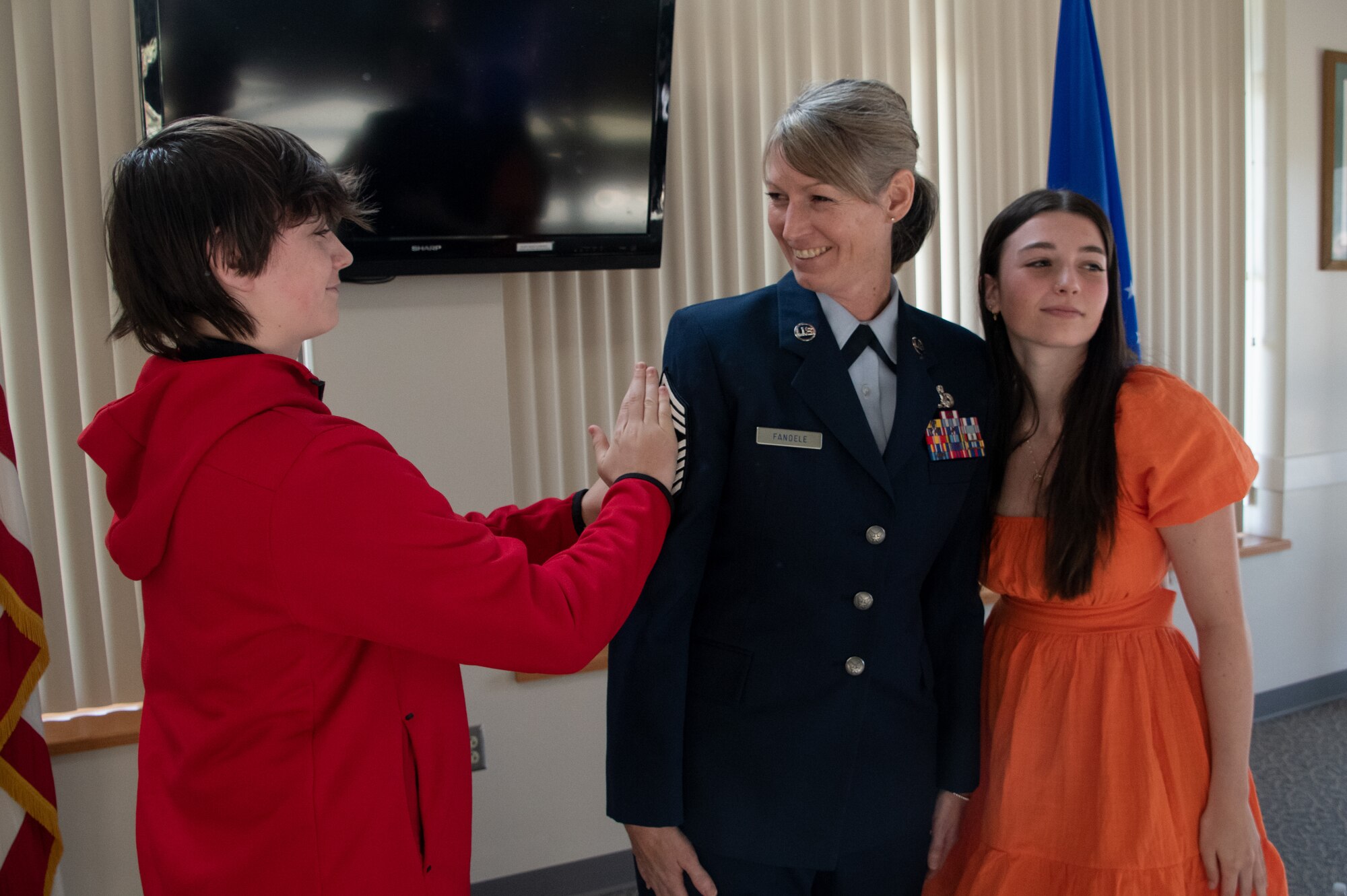 Chief Master Sgt. Jennifer Fanoele, 131st Bomb Wing Maintenance Operations Flight senior enlisted leader, receives her stripes from her son and her daughter at her promotion ceremony on the Royal Oak Golf Course, Knob Noster Missouri, April 1, 2023. Fanoele has served with distinction for 23 years and continues to be an asset to the Missouri Air National Guard. (U.S. Air National Guard photo by Senior Airman Kelly C. Ferguson)
