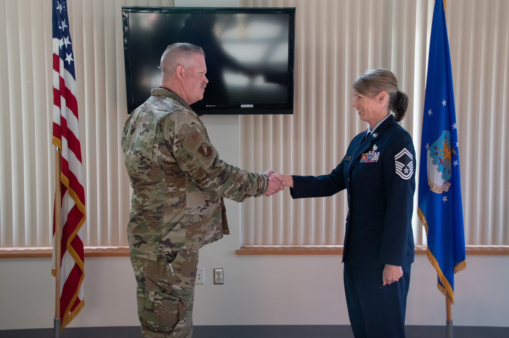 U.S. Air National Guard Lt. Col. Chad Larson, 131st Bomb Wing Maintenance Group commander, shakes hands with Chief Master Sgt. Jennifer Fanoele, 131st Bomb Wing Maintenance Operations Flight senior enlisted leader, at her promotion on the Royal Oak Golf Course, Knob Noster Missouri, April 1, 2023. Fanoele has served with distinction for 23 years and continues to be an asset to the Missouri Air National Guard. (U.S. Air National Guard photo by Senior Airman Kelly C. Ferguson)