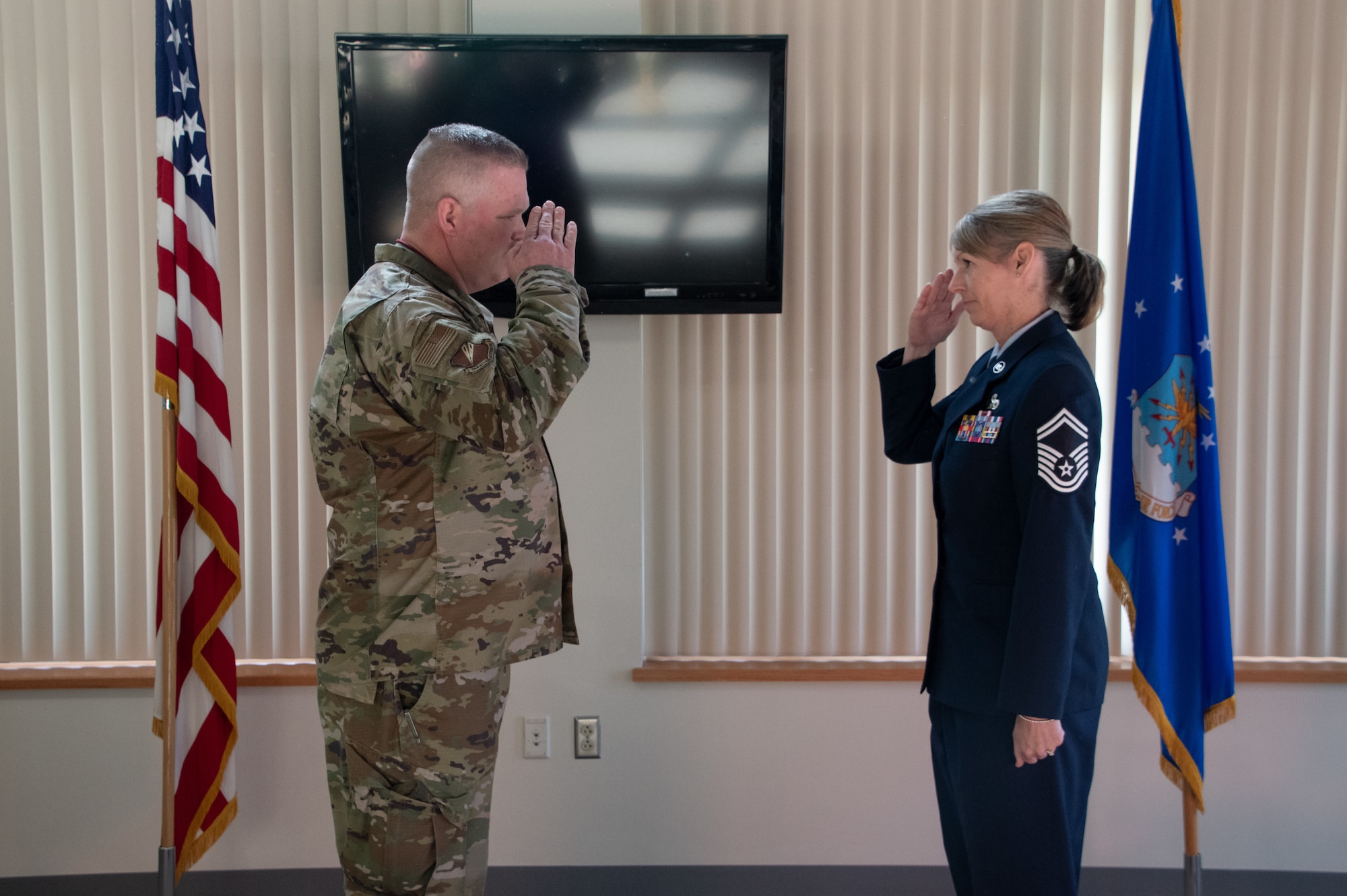 U.S. Air National Guard Lt. Col. Chad Larson, 131st Bomb Wing Maintenance Group commander, exchanges a salute with Chief Master Sgt. Jennifer Fanoele, 131st Bomb Wing Maintenance Operations Flight senior enlisted leader, at her promotion ceremony on the Royal Oak Golf Course, Knob Noster Missouri, April 1, 2023. Fanoele has served with distinction for 23 years and continues to be an asset to the Missouri Air National Guard. (U.S. Air National Guard photo by Senior Airman Kelly C. Ferguson)