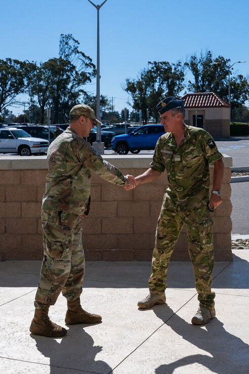  U.S. Space Force Lt. Col. Matthew Knepper, CJ5/8 Deputy Director, left, greets Royal New Zealand Air Force Air Commodore Shaun Sexton, Air Component Commander (ACC), in front of Combined Force Space Component Command headquarters at Vandenberg Space Force Base, Calif., April 21, 2023. As ACC, Sexton is responsible to the Chief of Air Force for the command, training and generation of Air Force Elements including all flying training, formations and activities that enable Air Surveillance and Response, Naval Air, Strategic Air, Theatre Air and Tactical Air capabilities. (U.S. Space Force photo by Tech. Sgt. Luke Kitterman)