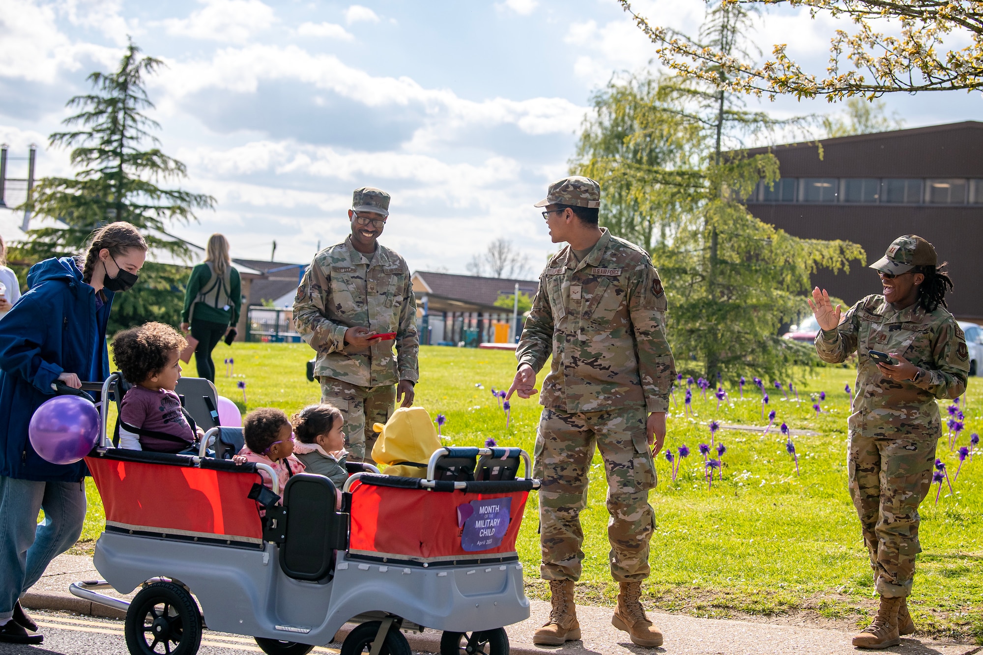 Airmen from the 501st Combat Support Wing cheer on their children during a Month of the Military Child Parade at RAF Alconbury, England, April 25, 2023. The parade was held to show gratitude for the sacrifices that come with being a military child. (U.S. Air Force photo by Staff Sgt. Eugene Oliver)