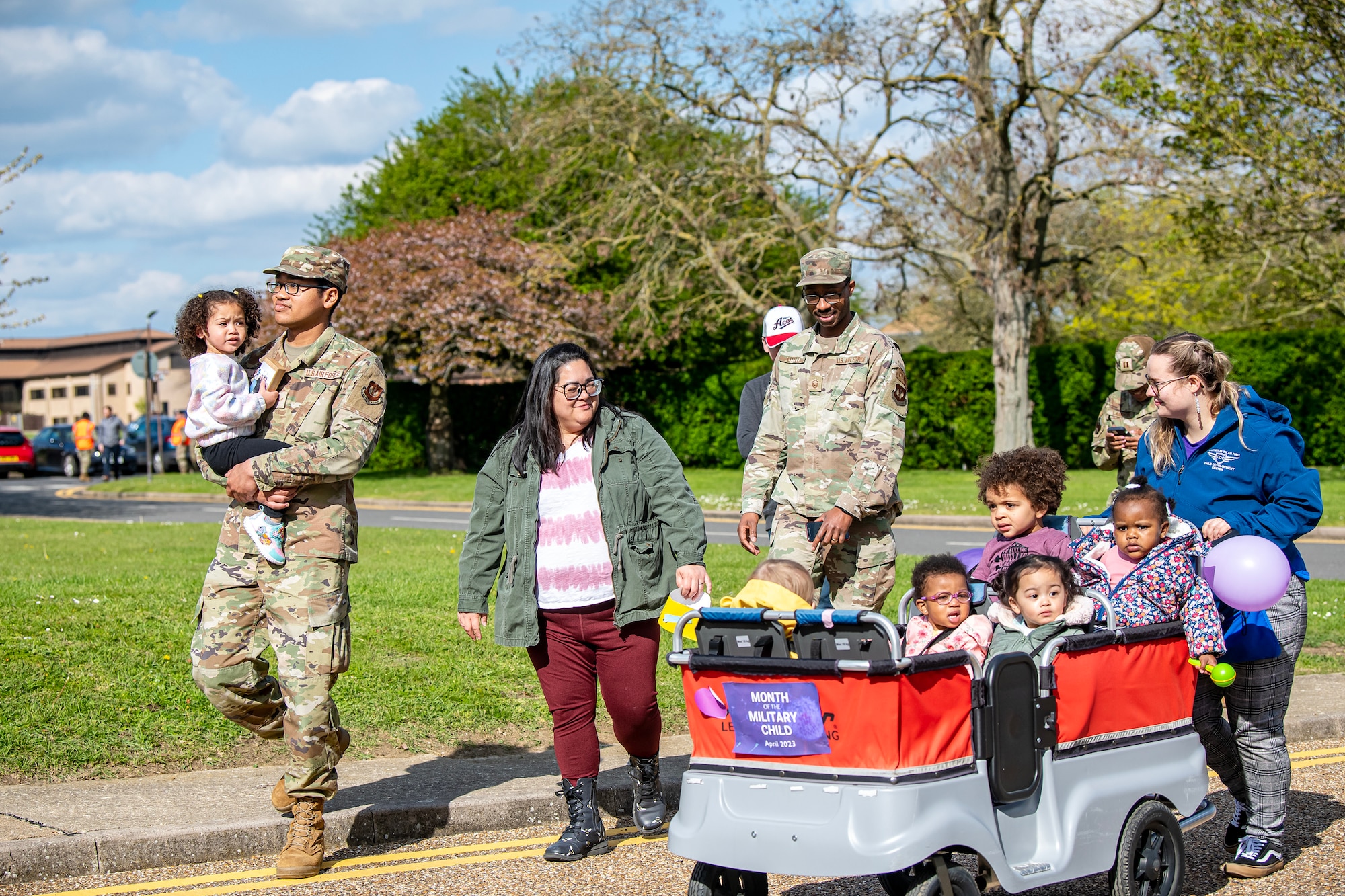 Children and parents walk in a Month of the Military Child Parade at RAF Alconbury, England, April 25, 2023. The parade was held to show gratitude for the sacrifices that come with being a military child. (U.S. Air Force photo by Staff Sgt. Eugene Oliver)