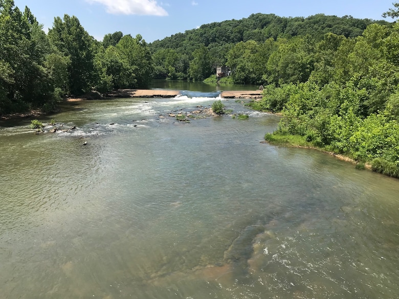 A rock outcrop sits in the Big Piney River.