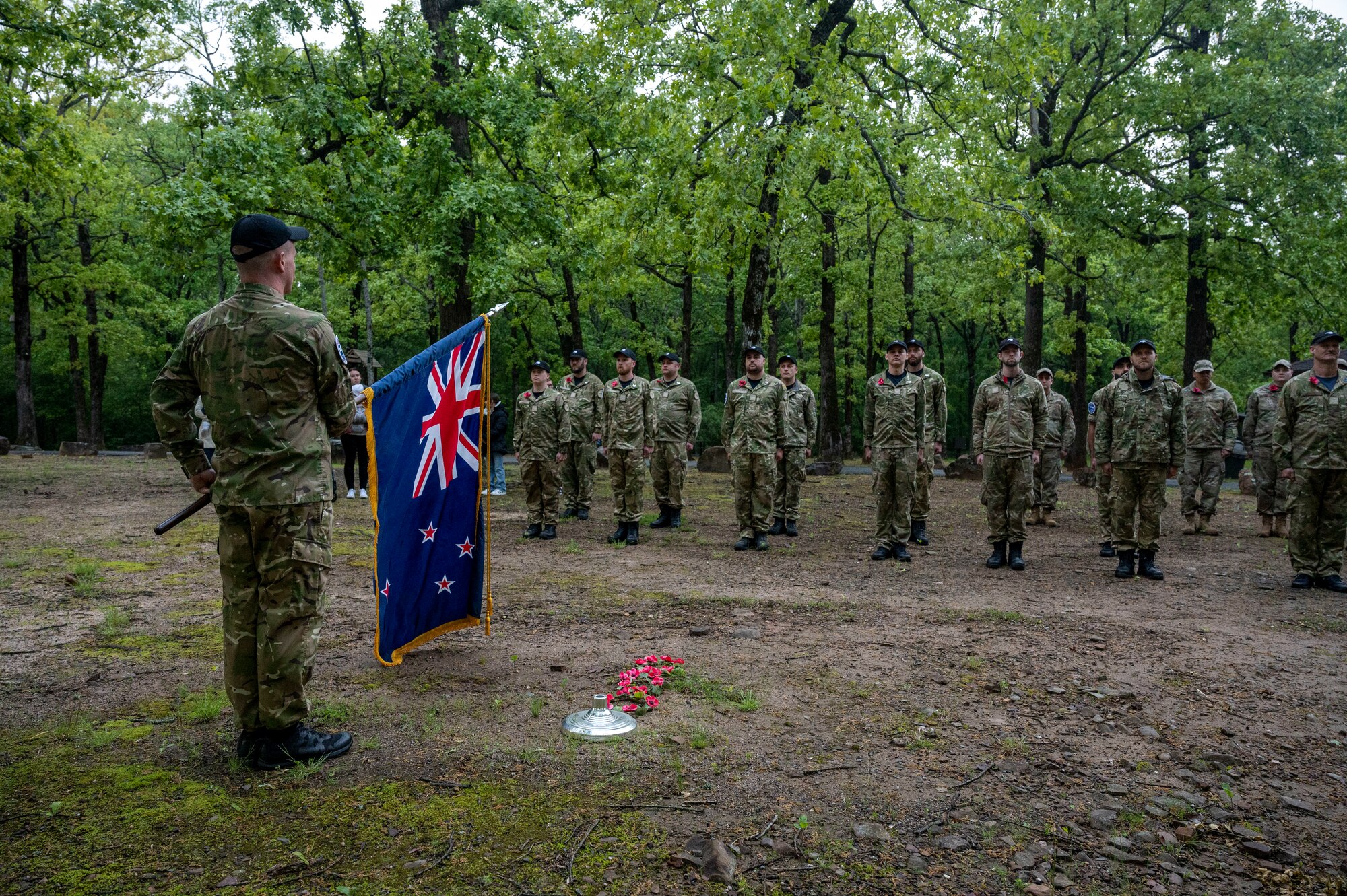 Members of the Royal New Zealand Air Force stand in formation and present the New Zealand flag