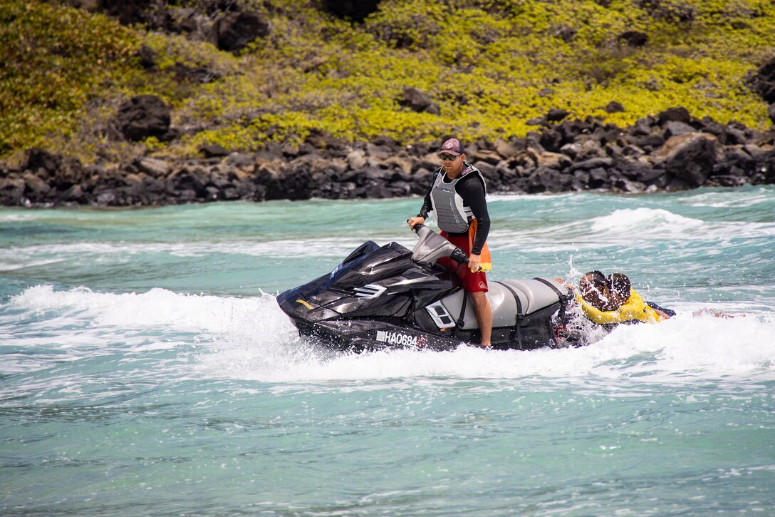 Kamakani Froiseth, a rescue operator with Honolulu City and County, demonstrates a safe water rescue during the Marine Corps Base Hawaii Water Safety Expo, Pyramid Rock Beach, MCBH, May 27, 2022. The Water Safety Expo was held in an effort to educate MCBH patrons on water safety, in order to prevent recreational mishaps and promote resiliency. (U.S. Marine Corps photo by Cpl. Samantha Sanchez)