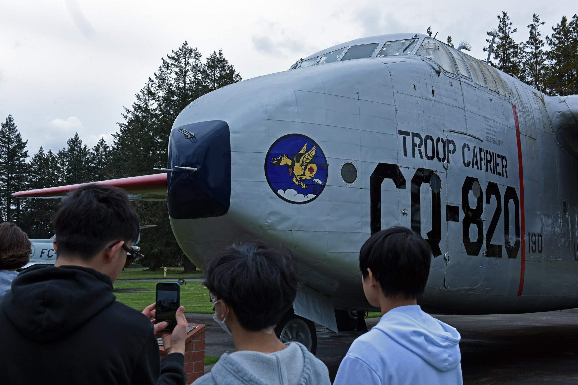 Olympia High School students take a photo of a C-82 Packet aircraft during a base tour at Heritage Hill on Joint Base Lewis-McChord, Washington, April 21, 2023. In addition to the airpark tour, the students also visited a C-17 Globemaster III simulator, received a mission briefing from Wing leadership and participated in an officer and enlisted Airmen question-and-answer panel to learn more about the Air Force. (U.S. Air Force photo by Staff Sgt. Zoe Thacker)