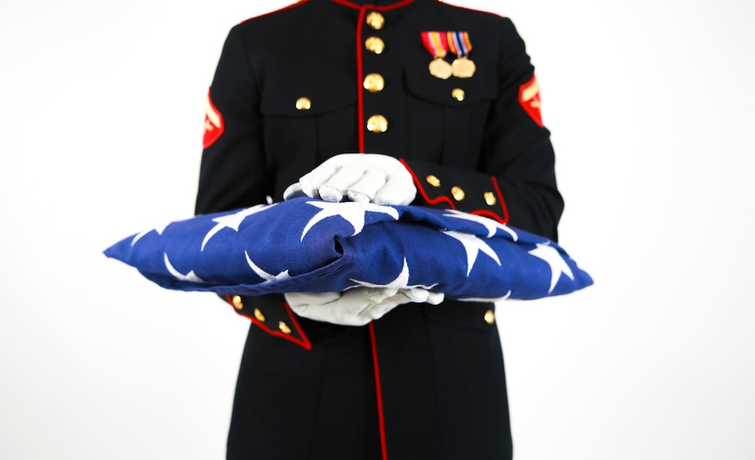 U.S. Marine Lance Cpl. Zachary Shull, detail commander with Ceremonial Platoon, Marine Corps Base Quantico, Va., stands holding a folded flag.  The folded flag is meant to pay homage and tribute to the original 13 colonies, and those who served. (U.S. Marine Corps Photo by Lance Cpl. Sean Potter)