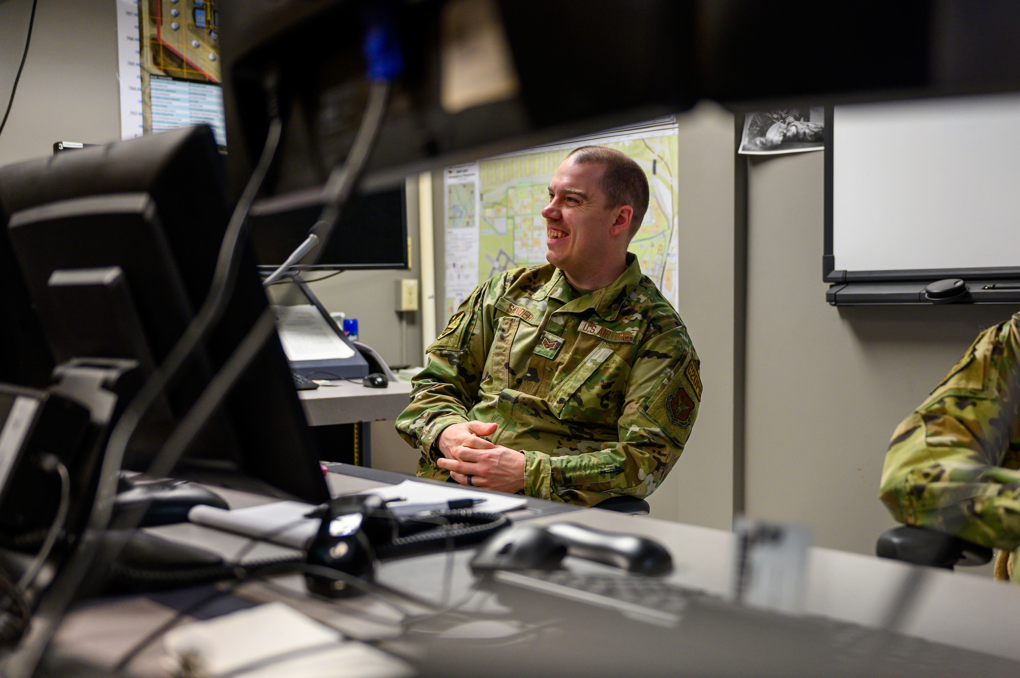 Senior Airman Jacob Sander, 934th Airlift Wing Command Post command post controller, converses with fellow Airmen at the Command Post at Minneapolis – St. Paul Air Reserve, Minnesota, April 1, 2023. Sander has been with the 934th AW Command Post for over two years. (U.S. Air Force photo by Master Sgt. Trevor Saylor)