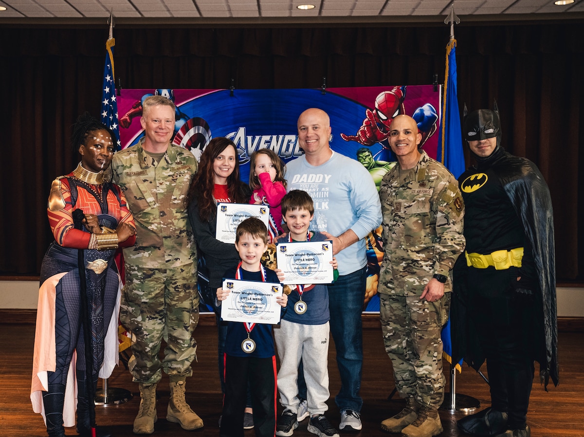 Col. Charles Barkhurst, 88th Air Base Wing vice commander, and Chief Master Sgt. Lloyd Morales, 88 ABW command chief, pose with a military family during the Little Heroes ceremony April 21 at the Wright-Patt Club on Wright-Patterson Air Force Base, Ohio.