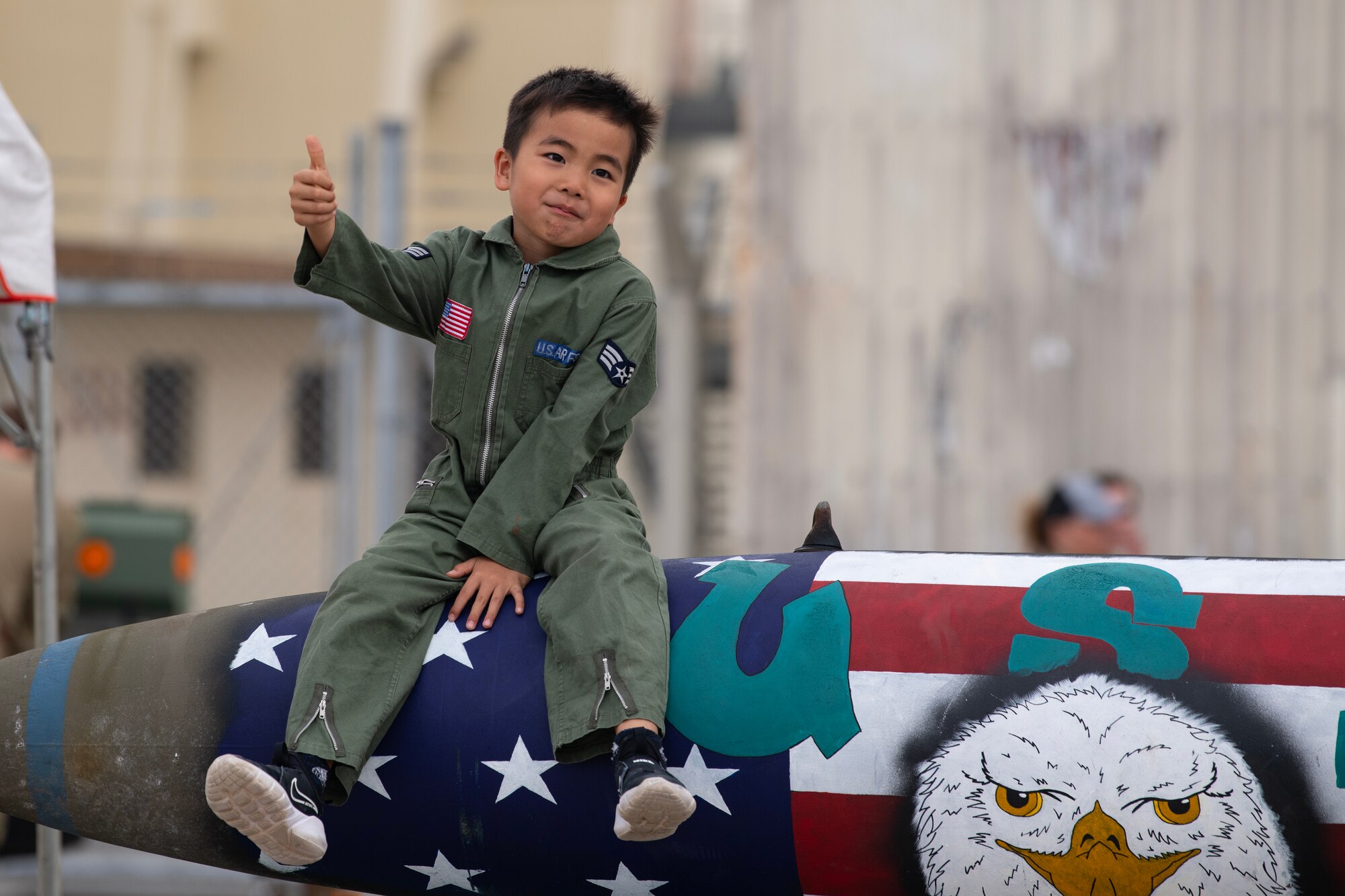 An America Fest 2023 attendee sits on a static display at Kadena Air Base, Japan, April 22, 2023. America Fest is Kadena Air Base’s open house event where attendees viewed static aircraft displays, interacted with U.S. service members and enjoyed a wide variety of entertainment and activities. (U.S. Air Force photo by Senior Airman Jessi Roth)