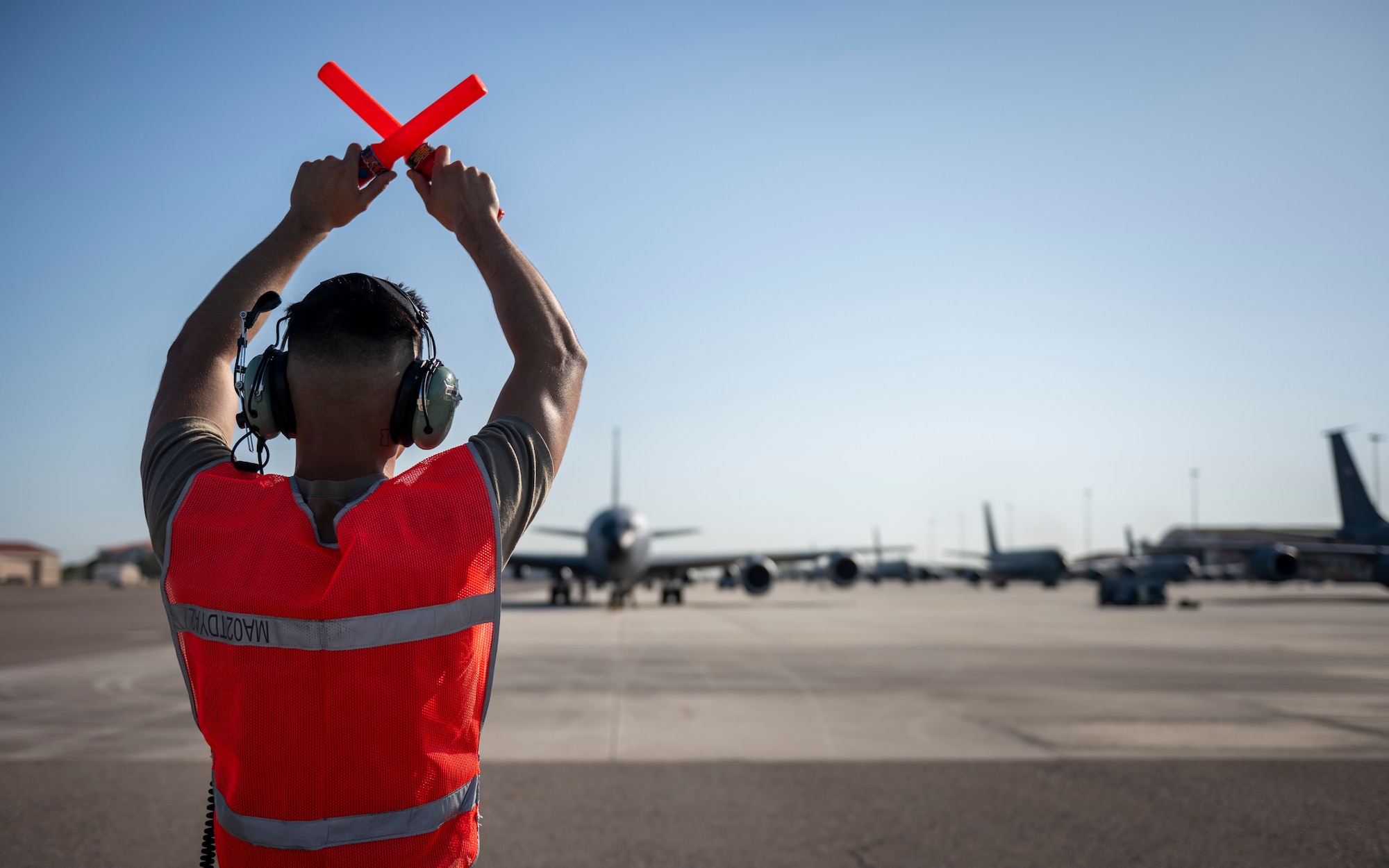 A crew chief with the 6th Maintenance Group marshals a KC-135 Stratotanker during Operation Violent Storm at MacDill Air Force Base, Florida, April 26, 2023. The exercise consisted of an “elephant walk,” with 18 KC-135 Stratotanker aircraft mobilizing through the efforts of more than 700 personnel from across the installation, all in under six hours. (U.S. Air Force photo by Senior Airman Lauren Cobin)
