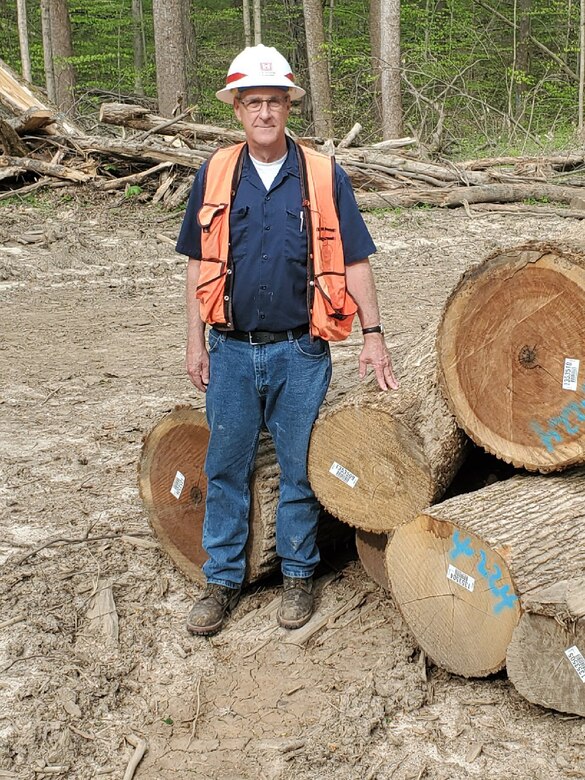 Barry Tucker, Louisville District forester, stands near harvested timber.
