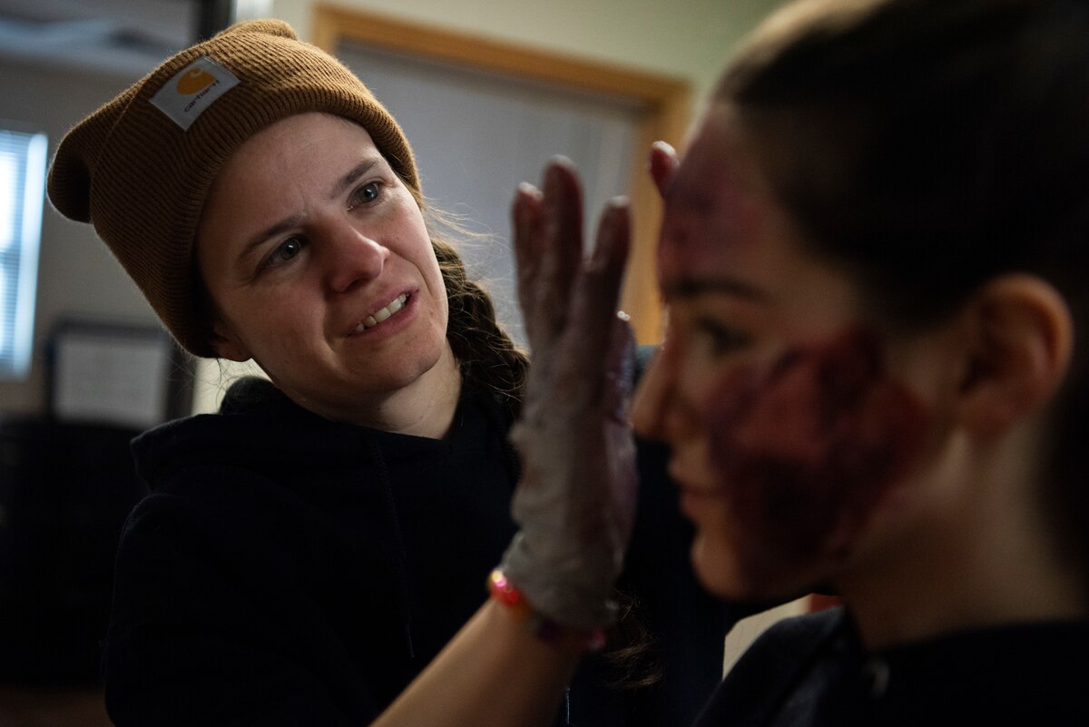 Image of an Airmen applying fake makeup.