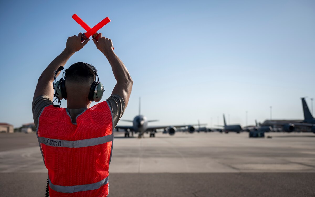 A crew chief with the 6th Maintenance Group marshals a KC-135 Stratotanker during Operation Violent Storm at MacDill Air Force Base, Florida, April 26, 2023. The exercise consisted of an “elephant walk,” with 18 KC-135 Stratotanker aircraft mobilizing through the efforts of more than 700 personnel from across the installation, all in under six hours. (U.S. Air Force photo by Senior Airman Lauren Cobin)
