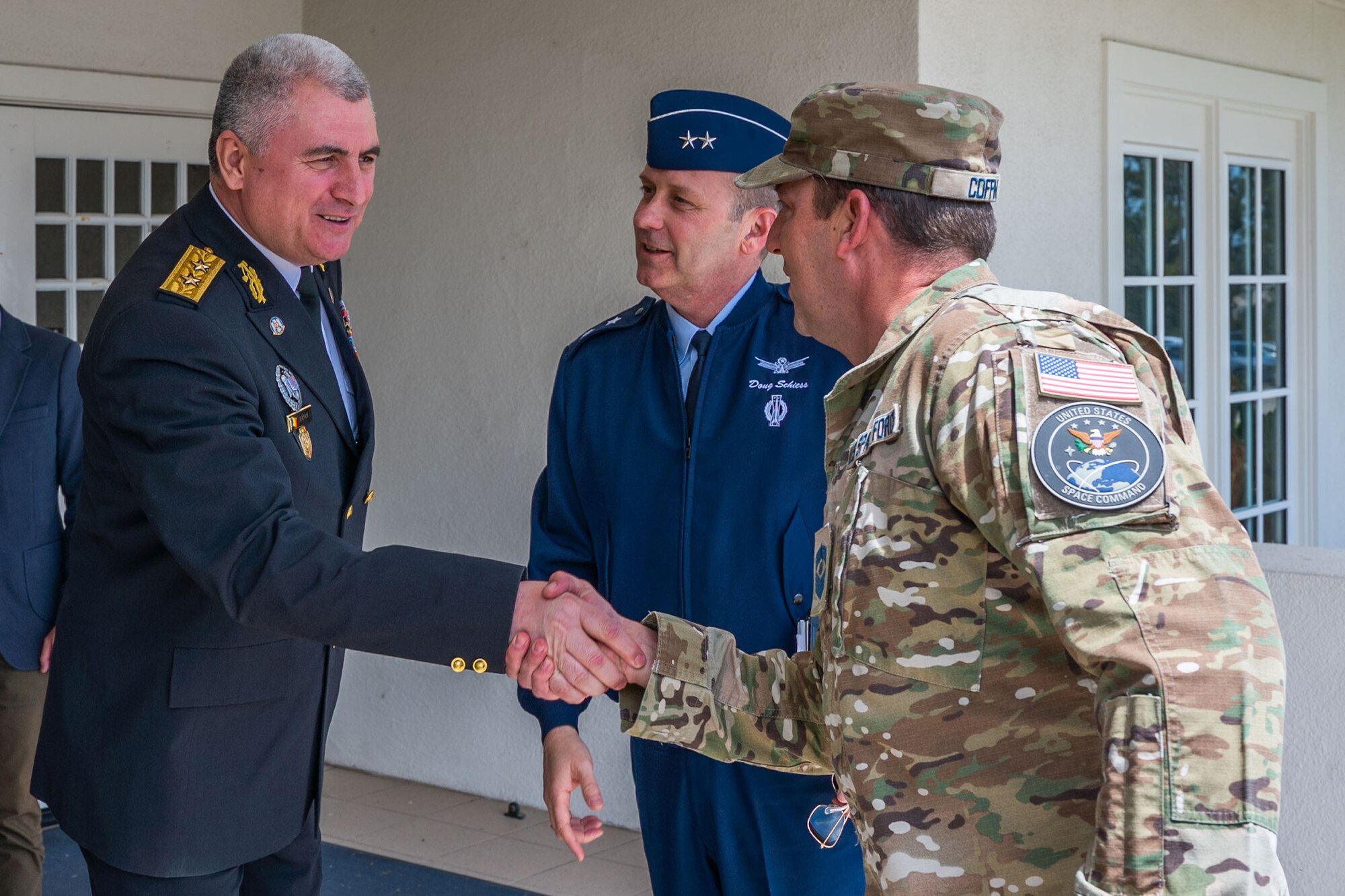 Maj. Gen. Adrian Brînză, Romanian Communications and Information Command commander, left, greets U.S. Space Force Maj. Gen. Douglas A. Schiess, Combined Force Space Component Command (CFSCC) commander, middle, and U.S. Space Force Chief Master Sgt. Grange S. Coffin, CFSCC senior enlisted leader, in front of the Pacific Coast Club on Vandenberg Space Force Base, Calif., April 25, 2023. A total of five Romanian representatives, two from
the Communications and Information Command and three from the Romanian Space Agency, immersed with CFSCC representatives for a full day to discuss Space Domain Awareness, command and control space operations, and benefits of Space Sharing Agreements. (U.S. Space Force photo by Tech. Sgt. Luke Kitterman)