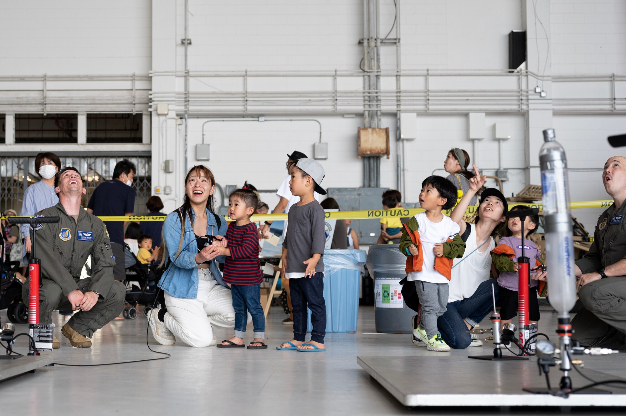 U.S. Air Force Airmen and festival attendees interact with a STEM Hangar exhibit during America Fest 2023 at Kadena Air Base, Japan, April 22, 2023. The 18th Wing unveiled its first STEM Hangar; an exhibit hall full of hands-on experiences designed to inspire youth to learn more about science, technology, engineering and mathematics through demonstrations from units across Kadena. (U.S. Air Force photo by Senior Airman Jessi Roth)