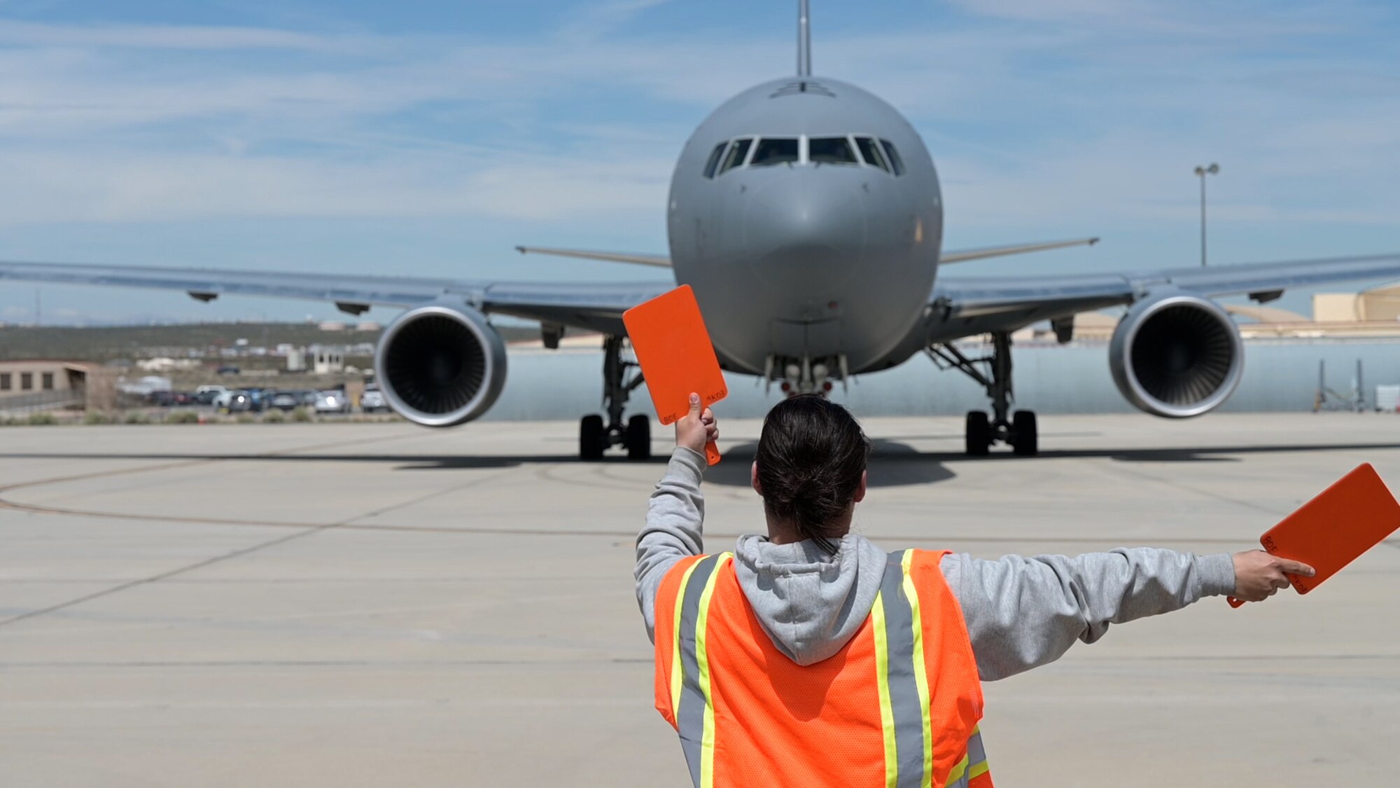 A Boeing maintainer guides a KC-46 Pegasus out of  of the flight-line to conduct an air refueling test mission at Edwards Air Force Base, Calif. It is a joint effort between Boeing, Air Mobility Command, Air Force Test Center, 418th Flight Test Squadron and Air Force Life Cycle Management Center to successfully complete the mission.