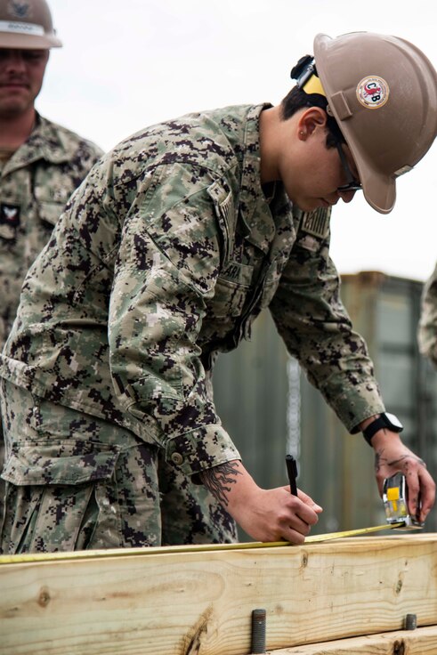 Builder Canostructionman Zeniada Lara, assigned to Naval Mobile Construction Battalion 133 (NMCB 133), measure the distance for floor joists during a technical trainer on Naval Construction Battalion Center Gulfport, Mississippi, April 24, 2023.