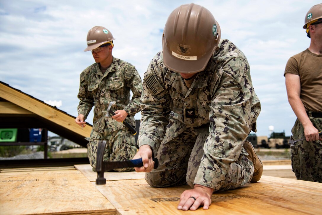 Builder 3rd Class Samuel Adcock, assigned to Naval Mobile Construction Battalion 133 (NMCB 133), builds the floor of a structure during a technical trainer on Naval Construction Battalion Center Gulfport, Mississippi, April 24, 2023.