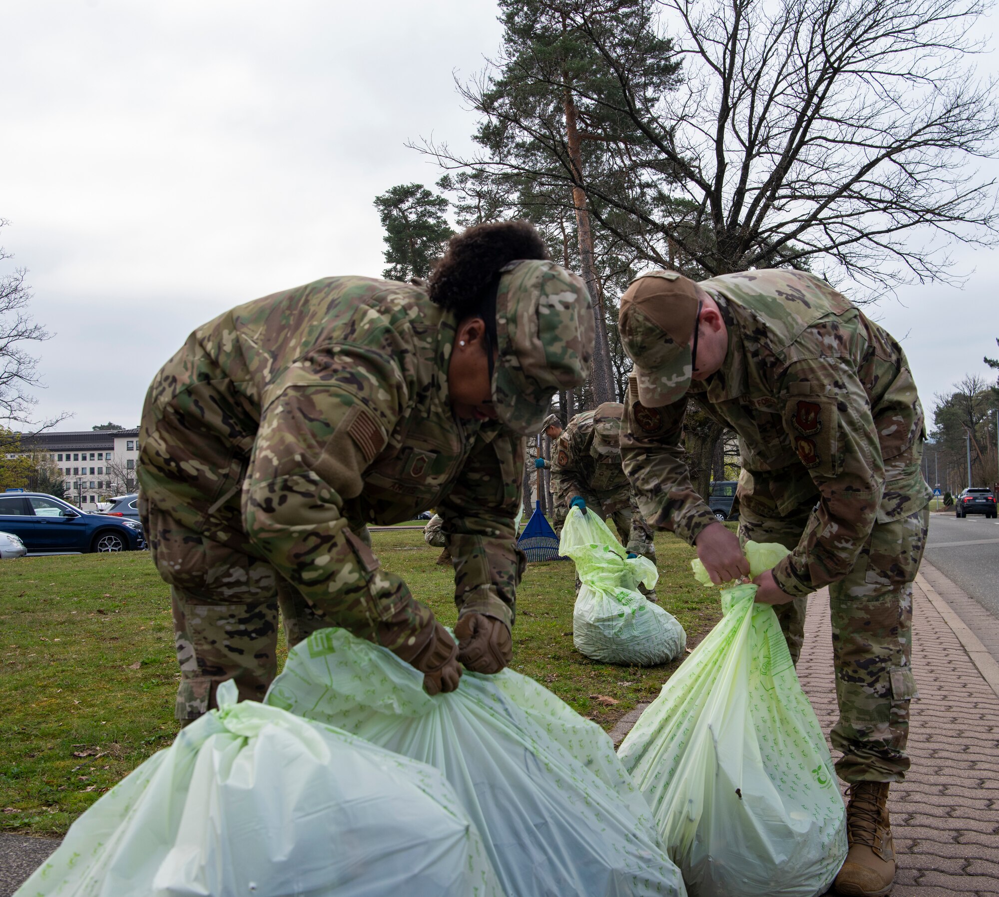 U.S. Air Force Airmen from the U.S. Air Forces in Europe--Air Forces Africa, A6 unified communications office, tie trash bags during Installation Excellence Day at Ramstein Air Base, Germany, April 18, 2023.