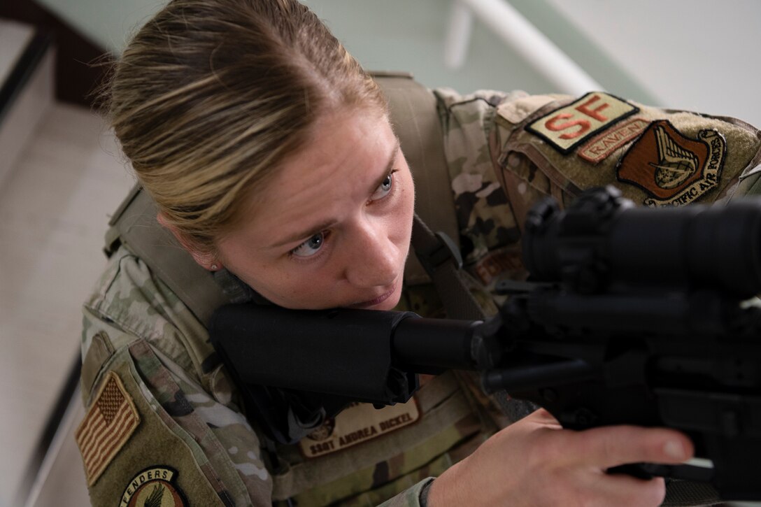An airman aims her weapon.